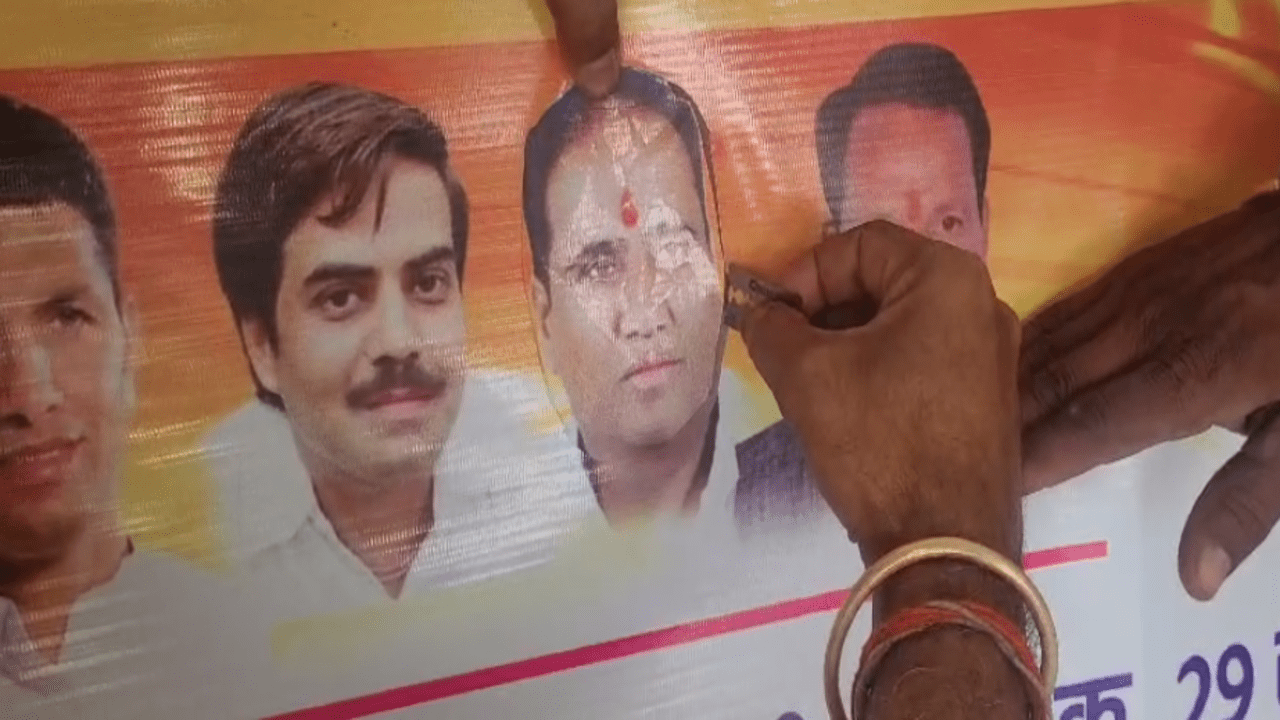 Guddu Sharma Congress worker cutting out the photo of former District President of Congress.