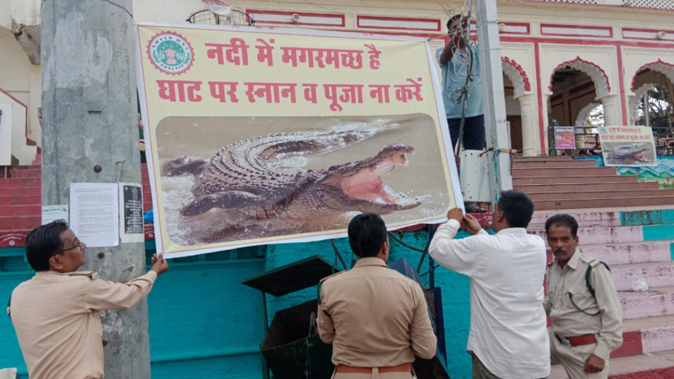 Forest department workers putting up posters at Sethani Ghat