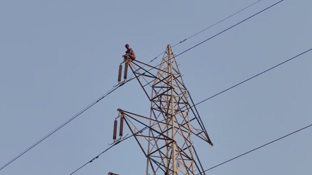 Drama of a young man by climbing on the tower of high tension line