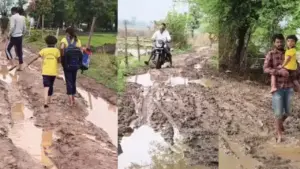 School children crossing a muddy path.